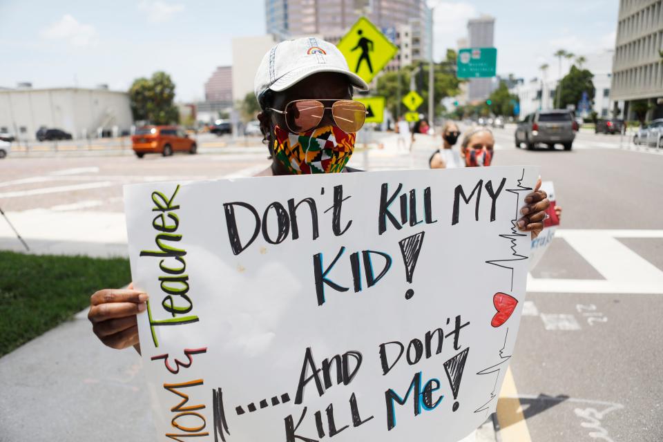 Business education teacher Malikah Armbrister stands in protest along with her colleagues in front of the Hillsborough County Schools District Office on July 16, 2020 in Tampa, Florida.