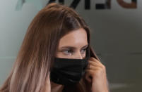 Belarusian Olympic sprinter Krystsina Tsimanouskaya, who came to Poland fearing reprisals at home after criticizing her coaches at the Tokyo Games, holds her face mask before she talks to journalists in Warsaw, Poland, Thursday, Aug. 5, 2021. (AP Photo/Czarek Sokolowski)