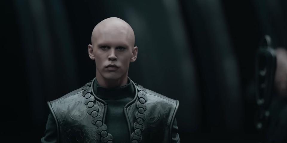 a character with no hair or eyebrows in black leather armor