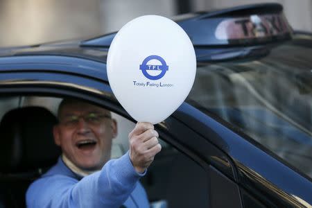 A London cab driver holds a balloon during a protest by London cab drivers against Uber in central London, Britain February 10, 2016. REUTERS/Stefan Wermuth