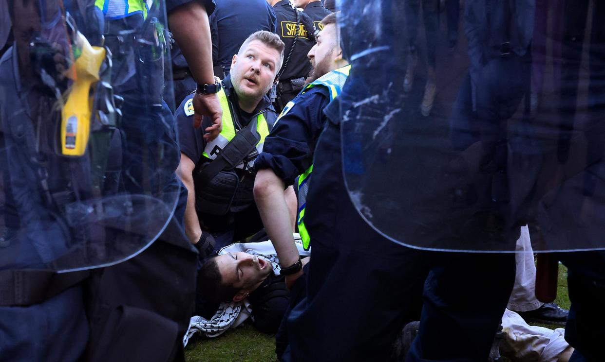 <span>Police detain a demonstrator as they work to remove an encampment at University of Wisconsin in Madison.</span><span>Photograph: John Hart/AP</span>