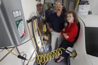 Connie and Travis Jones pose with their 2003 natural gas powered Honda Civic and natural gas home refueling station located on the garage wall of their home in Chandler, Arizona, October 3, 2013. (REUTERS/Ralph D. Freso)