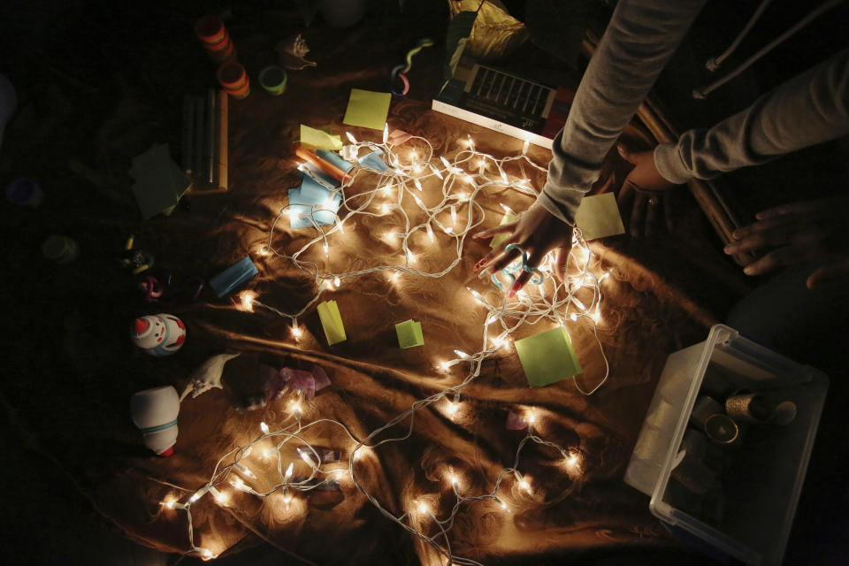 A girl touches a sensory toy in an altar of comforting objects during a meeting for the "Sisters in Strength" in the Brooklyn borough of New York on Wednesday, March 6, 2019. Various studies have found that 7 in 10 girls endure some form of sexual harassment by age 18, and 1 in 4 will be sexually abused. Experts believe the rates are higher for girls of color. (AP Photo/Wong Maye-E)