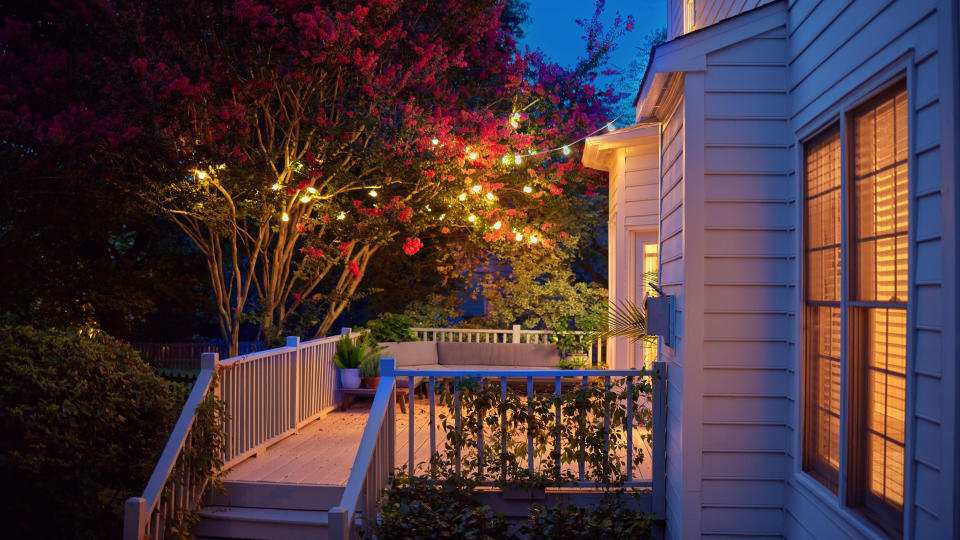 The exterior front of a house lit with soft hanging lights