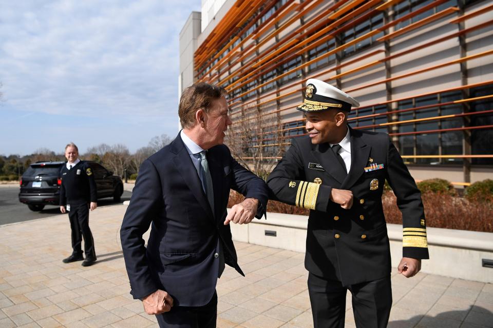 U.S. Surgeon General Vice Admiral Jerome M. Adams, right, bumps elbows with Connecticut Gov. Ned Lamont as they meet for a visit the Connecticut State Public Health Laboratory, Monday, March 2, 2020, in Rocky Hill, Conn.