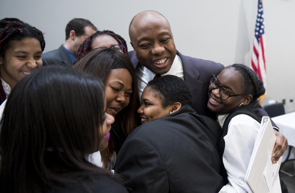 Sen. Tim Scott (R-S.C.) gives a group hug to students from the Richard Wright Public Charter School in Washington, D.C., during his National School Choice Forum in the Hart Senate Office Building on Feb. 9, 2015.