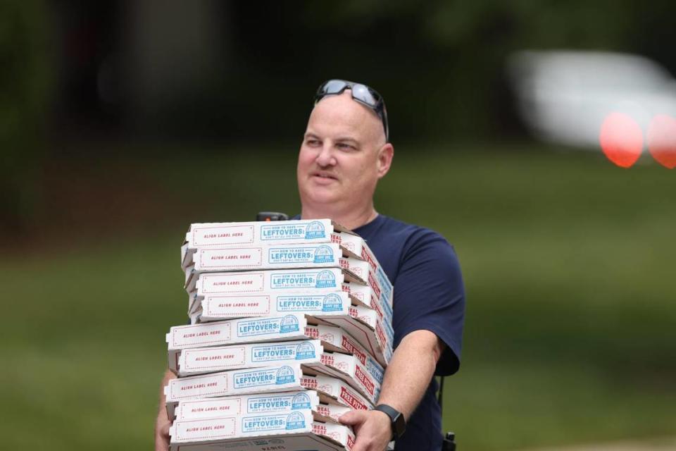 Food is brought in for people who working the scene of a massive fire spread across at least two structures and threatened others in Charlotte’s South Park neighborhood Thursday morning.