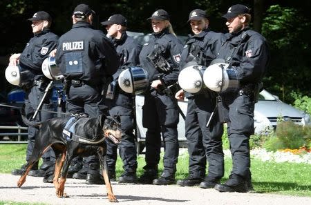 A dog passes a row of police men during a G20 demonstration against the ban of Hamburg's authorities of a G20 protestors camp in the Stadtpark park in Hamburg, Germany June 26, 2017. REUTERS/Fabian Bimmer