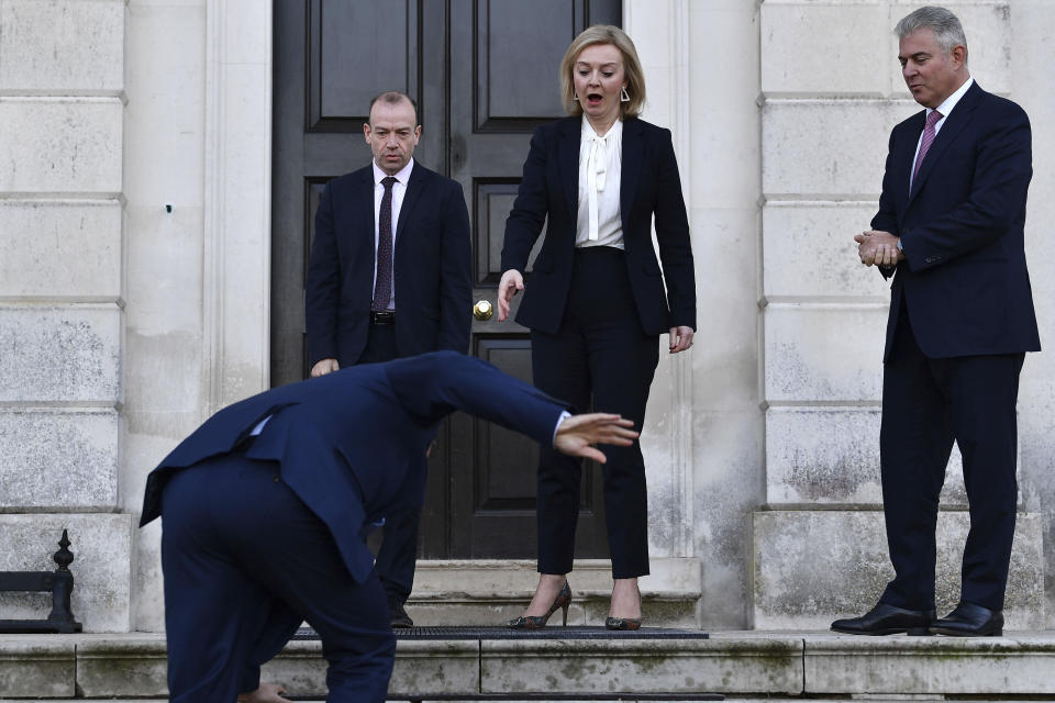 Foreign Secretary Liz Truss, center, Minister of State for Europe Christopher Heaton-Harris, left, and Secretary of State for Northern Ireland Brandon Lewis react as EU post-Brexit negotiator Maros Sefcovic slips on an icy step upon his arrival for a meeting at Chevening in Kent, England, Thursday, Jan. 13, 2022. Top negotiators from Britain and the European Union are meeting in hope of resolving their a thorny dispute over Northern Ireland trade. (Ben Stanstall/Pool Photo via AP)