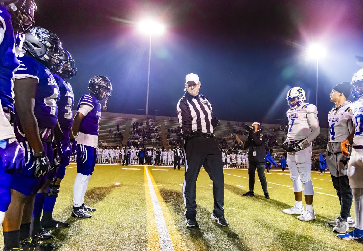 The referee displays the coin before his pregame coin toss between LBJ and Pflugerville in last week's bi-district playoff game at Nelson Field. LBJ won that game and on Friday plays Huntsville in the area round of the Class 5A Division II playoffs. That game is at Waco ISD stadium.