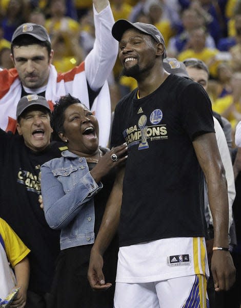 Golden State Warriors forward Kevin Durant, right, celebrates with his mother Wanda Durant as he is named the NBA Finals Most Valuable Player after Game 5 of basketball's NBA Finals between the Warriors and the Cleveland Cavaliers in Oakland, Calif., Monday, June 12, 2017. The Warriors won 129-120 to win the NBA championship. (AP Photo/Marcio Jose Sanchez)