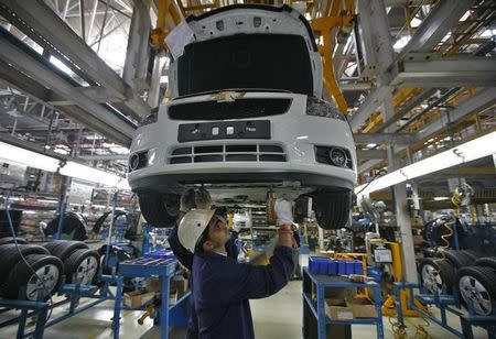 Employees work on the Chevrolet Cruze assembly line inside a plant of General Motors India Ltd. at Halol, east of Ahmedabad, September 22, 2010. REUTERS/Amit Dave/Files