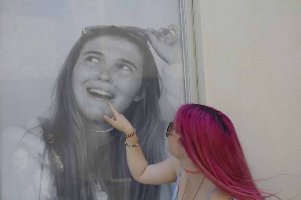 Kirra Larese, an incoming Ventura High senior, interacts with her portrait on a library window.