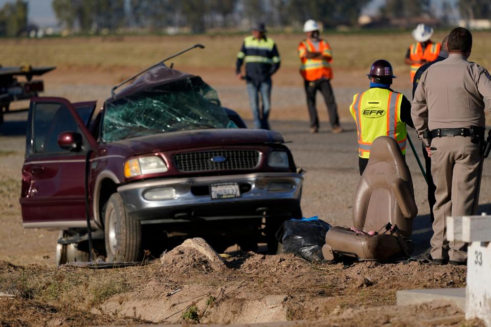 Law enforcement officers sort evidence and debris at the scene of a deadly crash in Holtville, Calif., on March 2. Authorities say a semitruck crashed into an SUV carrying 25 people on a Southern California highway, killing at least 13 people.