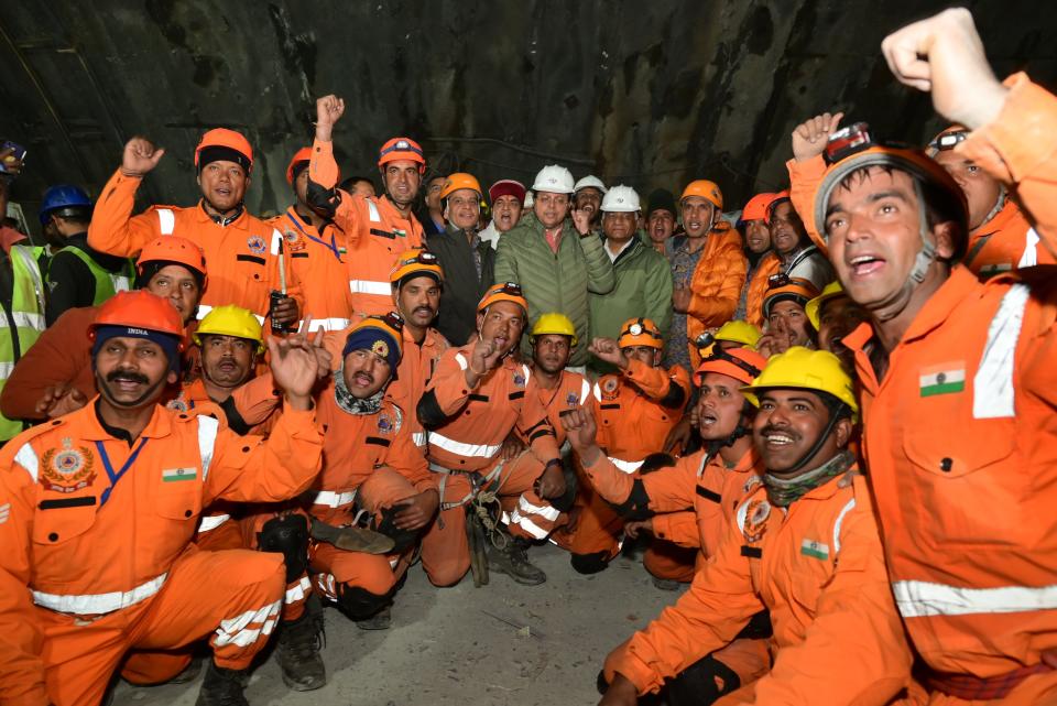 This handout photo provided by the Uttarakhand State Department of Information and Public Relations shows rescue workers cheer, along with Pushkar Singh Dhami, Chief Minister of Uttarakhand state, center wearing white helmet, and Indian Minister of State of Road Transport and Highways V.K. Singh, center right, in the northern Indian state of Uttarakhand, India, Tuesday, Nov. 28, 2023. All 41 construction workers who were trapped in a collapsed mountain tunnel for more than two weeks were pulled out on Tuesday, bringing a happy end to a drawn-out rescue mission. (Uttarakhand State Department of Information and Public Relations via AP)