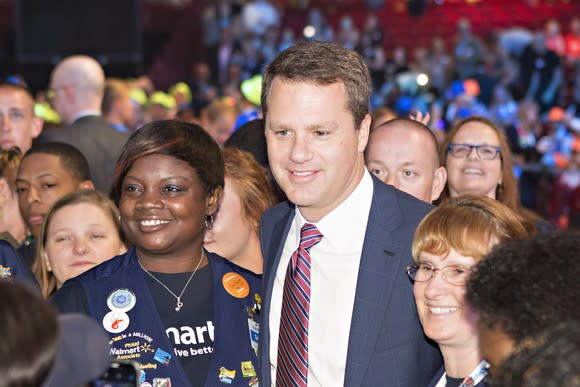 Walmart CEO Doug McMillon surrounded by employees.