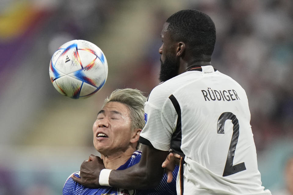 Japan's Takuma Asano, left, fights for the ball with Germany's Antonio Ruediger during the World Cup group E soccer match between Germany and Japan, at the Khalifa International Stadium in Doha, Qatar, Wednesday, Nov. 23, 2022. (AP Photo/Luca Bruno)