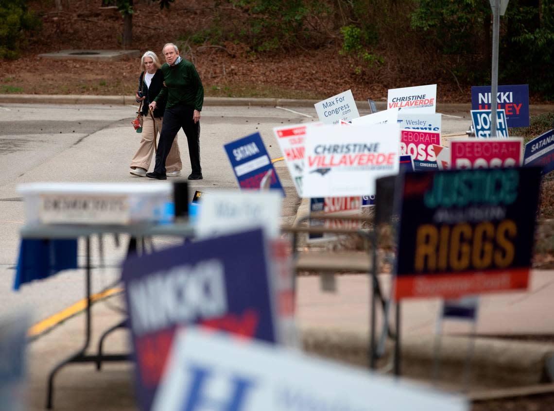 People walk by campaign signs outside of a voting location at the Herbert C. Young Community Center in Cary, N.C. on Tuesday, March 5, 2024. Kaitlin McKeown/kmckeown@newsobserver.com