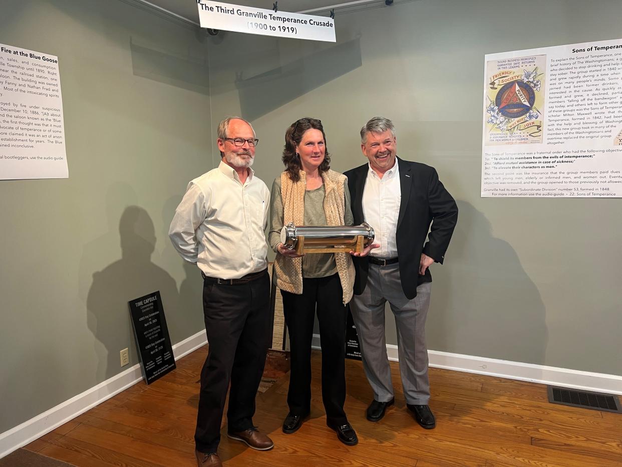 Granville Area Chamber of Commerce Executive Director Steve Matheny, Mayor Melissa Hartfield and resident Brian Edwards, who proposed 43023 Day, pose with the Granville time capsule, set to be interred for the next 99 years at the Granville Historical Society.