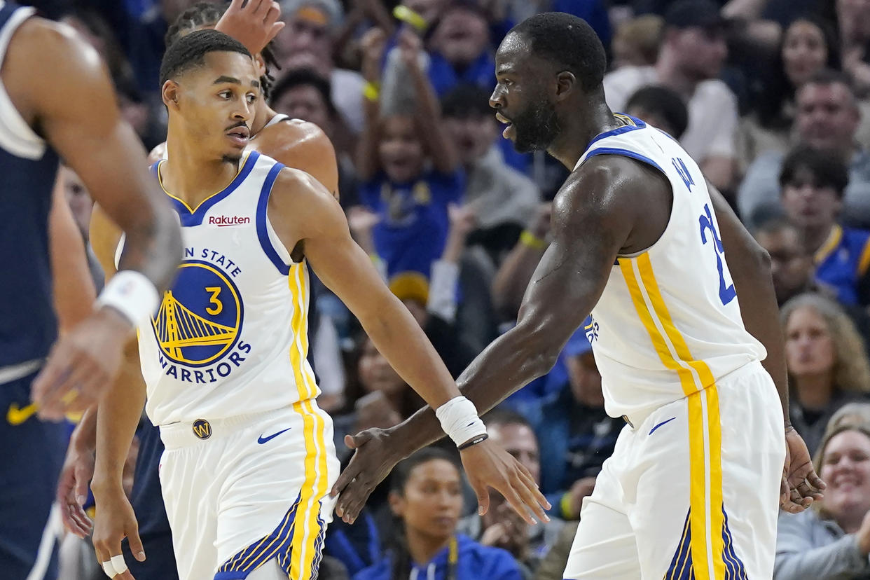 Golden State Warriors guard Jordan Poole and forward Draymond Green slap hands during a preseason NBA game Oct. 14, 2022 after Green returned to the team following a practice altercation in which he punched Poole. (AP Photo/Jeff Chiu)