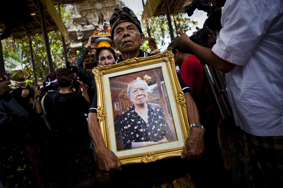 UBUD, BALI, INDONESIA - AUGUST 18: A relative holds a picture of Anak Agung Rai Niang during the Hindu Royal cremation - also know as the Pengabenan - for the late mother of Gianyar Regent, Tjokorda Oka Artha Ardana Sukawati, at Puri Ubud in Gianyar Bali on August 18, 2011 in Ubud, Bali, Indonesia. Niang Rai died in a Denpasar hospital in May; and will involve a nine level, 24m high 'bade' or body carring tower, made by upto 100 volunteers from 14 local villages. It will be carried to the cremation by 4500 Ubud residents. (Photo by Ulet Ifansasti/Getty Images)