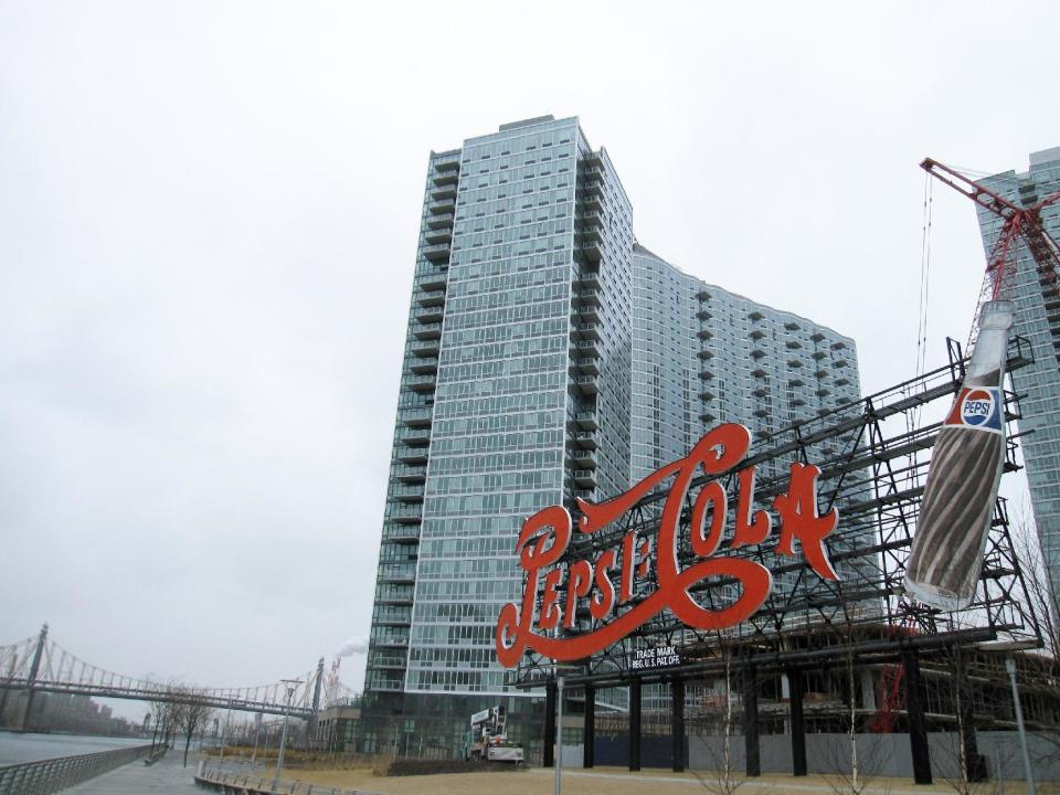 This March 7, 2013 photo shows the bright red Pepsi-Cola sign on the waterfront of Long Island City, in the Queens borough of New York. The beloved landmark can be seen from across the river in Manhattan. At one time the sign was located at the site of a local soda bottling factory. The factory no longer exists but the popular sign, which dates to the 1930s, was preserved as part of a waterfront park called Gantry Plaza State Park. In the distance the Ed Koch Queensborough Bridge and the smokestacks of a power generating plant are visible. The area is becoming popular with tourists due to a boom there in moderately priced hotels.(AP Photo/Beth J. Harpaz)