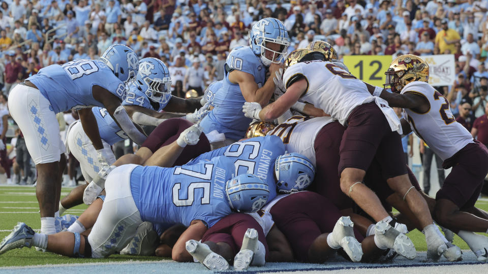 North Carolina quarterback Drake Maye, top, is stopped by Minnesota linebacker Maverick Baranowski (6) trying to dive over the line for a score on a short yardage quarterback keeper play during the second half of an NCAA college football game, Saturday, Sept. 16, 2023, in Chapel Hill, N.C. (AP Photo/Reinhold Matay)