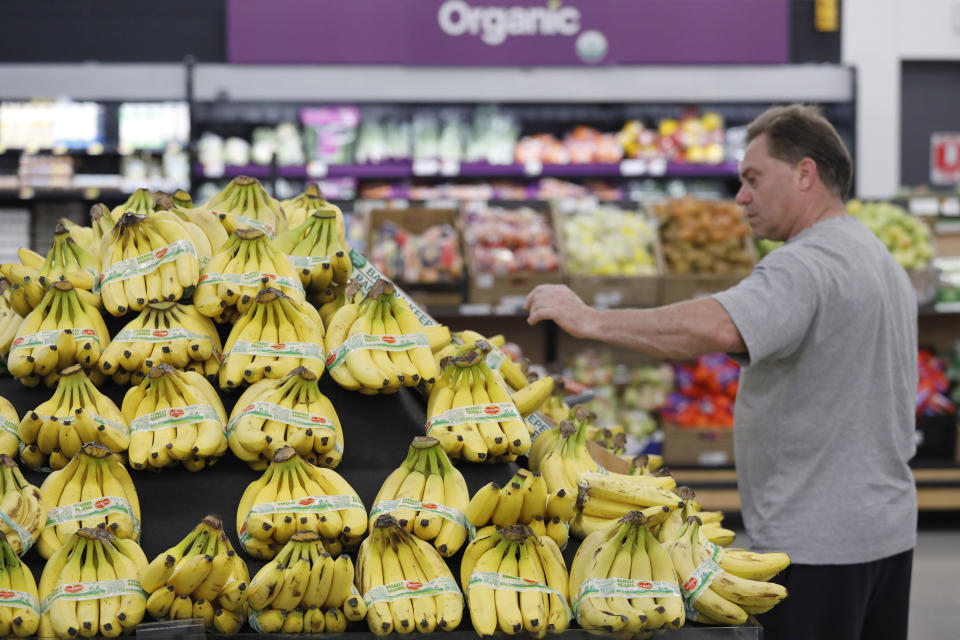 A customer shops for bananas at a Walmart Neighborhood Market, Wednesday, April 24, 2019, in Levittown, N.Y. High resolution cameras suspended from the ceiling point to the table of bananas and determine from the color of the bananas how ripe they are. When a banana starts to bruise, that would send an alert to an associate to replenish. (AP Photo/Mark Lennihan)