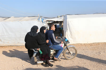 Syrian refugees ride on a motorbike at a refugee camp in Akkar, northern Lebanon, November 27, 2018. REUTERS/Mohamed Azakir