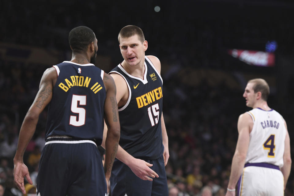 Denver Nuggets center Nikola Jokic (15) talks with forward Will Barton III (5) after Jokic was fouled during the second half of an NBA basketball game against the Los Angeles Lakers Sunday, Dec. 22, 2019, in Los Angeles. The Nuggets won 128-104. (AP Photo/Michael Owen Baker)