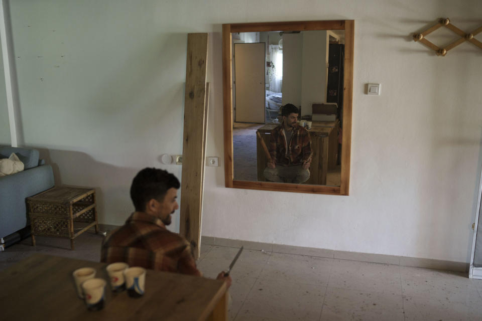 Holding a knife and rolling pin, Nadav Tzabari describes how he prepared to protect his husband and himself in their home during the Oct. 7, 2023, Hamas attack in Kibbutz Nahal Oz, Israel, Wednesday, Feb. 7, 2024. (AP Photo/Leo Correa)