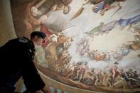 U.S. Capitol Hill Policemen Adam Taylor looks out at Constantino Brumidi's painting "The Apotheosis of Washington" on the "eye" or ceiling of the U.S. Capitol's rotunda during a media tour of the capitol dome on Capitol Hill in Washington, December 19, 2013. Americans longing for a makeover in Washington will get their wish partially granted as the dome of the U.S. Capitol - but not the lawmakers who work inside - undergoes a facelift. The dome of the capitol building will be undergoing a restoration project to halt deterioration of the dome's cast iron as well as ensure the protection of the interior of the dome and rotunda. (REUTERS/Douglas Graham/POOL)