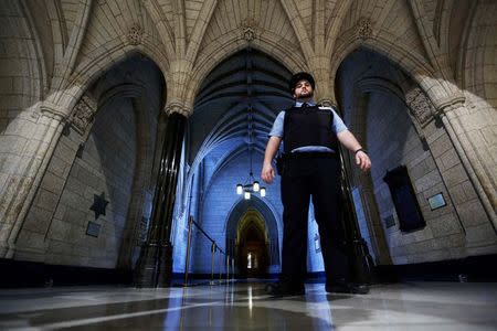 A security guard patrols the hallway near the entrance to the Parliamentary Library on Parliament Hill in Ottawa October 23, 2014 following a shooting incident October 22, in which a gunman killed a soldier and ran through Parliament shooting before being shot dead himself near the library. REUTERS/Chris Wattie