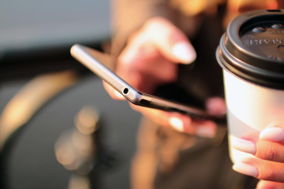 Woman on phone holding coffee