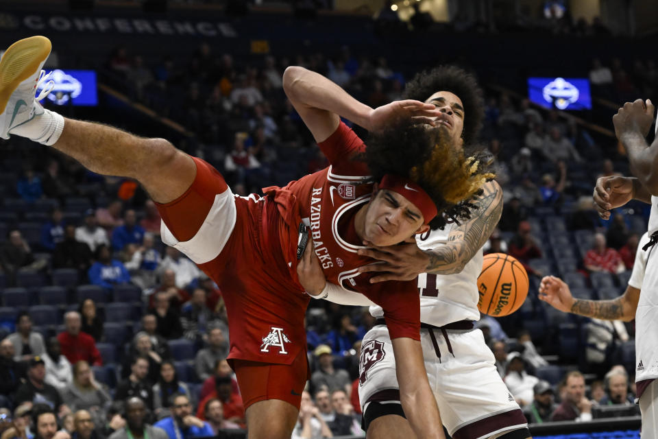 Arkansas guard Anthony Black, left, is fouled by Texas A&M forward Andersson Garcia, right, while shooting during the first half of an NCAA college basketball game in the quarterfinals of the Southeastern Conference Tournament, Friday, March 10, 2023, in Nashville, Tenn. (AP Photo/John Amis)