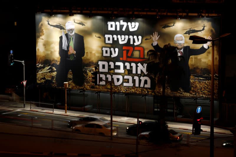 A billboard over a Tel Aviv highway shows photo-shopped warzone images of Palestinian President Mahmoud Abbas and Hamas leader Ismail Haniyeh, both blindfolded, with the slogan read in Hebrew "Peace is Made ONLY with Defeated Enemies\