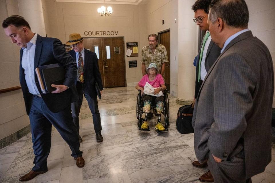 Linda Siegrist, 69, a double amputee, is pushed in her wheelchair by her husband Bruce, 67, after a hearing in Sacramento Superior Court on May 18 to decide if she can keep her childhood home. The hearing was also attended by Bay Area Receivership Group representatives Gerald Keena and Dan Collins, left, and city of Sacramento attorneys Gus Martinez and Kevin Kundinger.