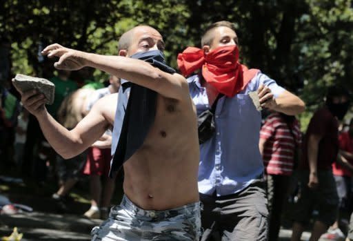 Demonstrators throw rocks at riot policemen during a miners' demonstration in Madrid. Spain's Prime Minister Mariano Rajoy announced Wednesday a 65-billion-euro austerity package to avert financial collapse as protesters against mining cuts clashed with police