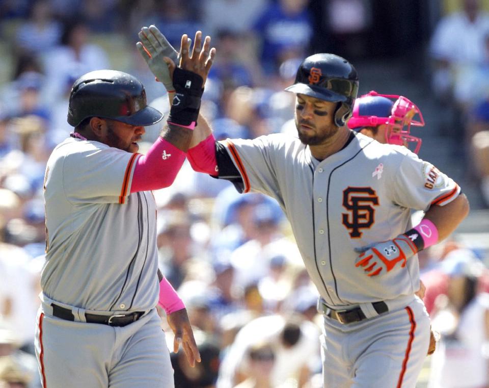 San Francisco Giants' Pablo Sandoval, left, congratulates Brandon Hicks for hitting a two-run home run in the seventh inning of a baseball game against the Los Angeles Dodgers on Sunday, May 11, 2014, in Los Angeles. (AP Photo/Alex Gallardo)