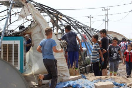 Displaced people inspect tents that were destroyed by fire at Yahayawa refugee camp near Kirkuk, Iraq, August 29, 2016. REUTERS/Ako Rasheed