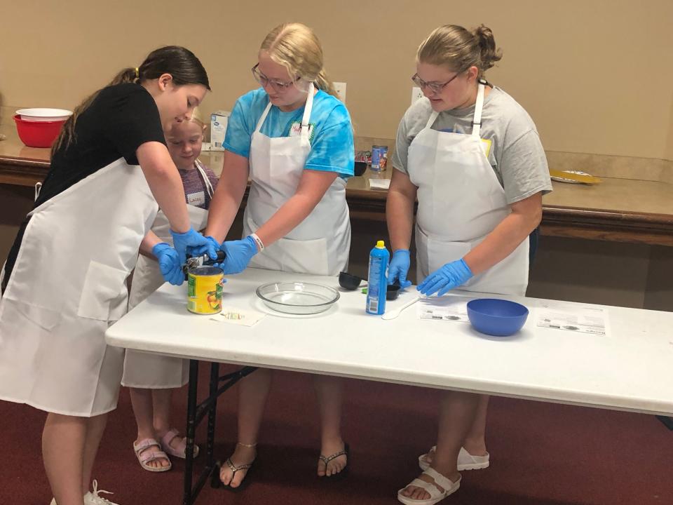 The menu for the Bucyrus Public Library cooking camp featured everything from spaghetti and stir fry to peach crisp and fruit pizza. After donning the aprons, one of the participants exclaimed, "We look like scientists!"