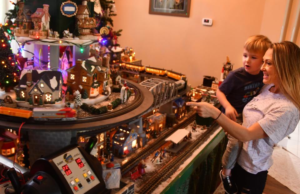 Marisa Graybeal and her son Reagan, 3, wait for a train to circle Willard Davis' expansive Christmas village in his Suntree living room.