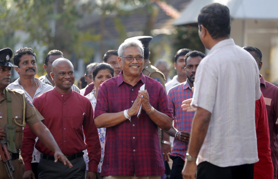 Sri Lanka's former Defense Secretary and presidential candidate Gotabaya Rajapaksa, center, leaves a polling station after casting his vote in Embuldeniya, on the outskirts of Colombo, Sri Lanka, Saturday, Nov. 16, 2019. Polls opened in Sri Lanka’s presidential election Saturday after weeks of campaigning that largely focused on national security and religious extremism in the backdrop of the deadly Islamic State-inspired suicide bomb attacks on Easter Sunday. (AP Photo/Eranga Jayawardena)