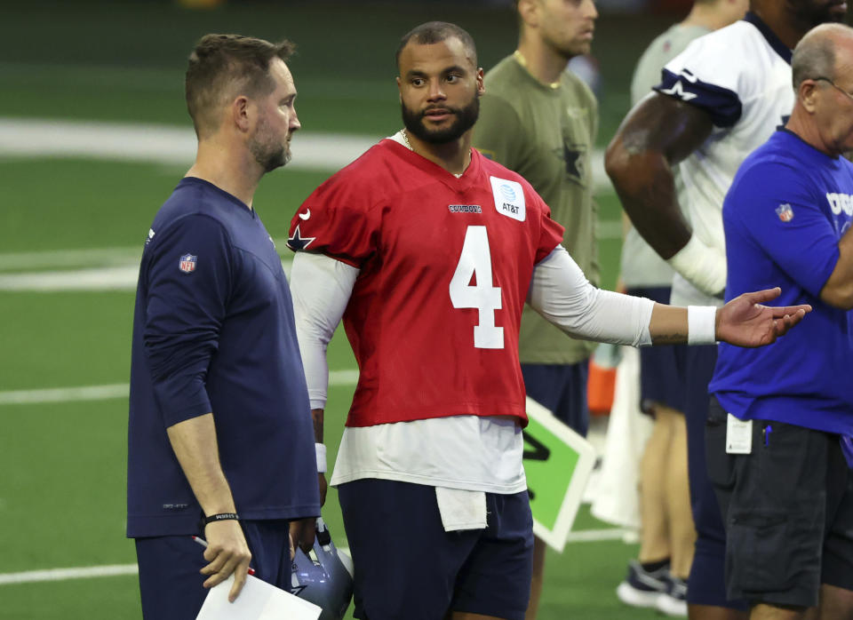 Dallas Cowboys quarterback Dak Prescott (4) talks with offensive coordinator Brian Schottenheimer during an NFL football practice, Tuesday, June 6, 2023, in Frisco, Texas. (AP Photo/Richard W. Rodriguez)