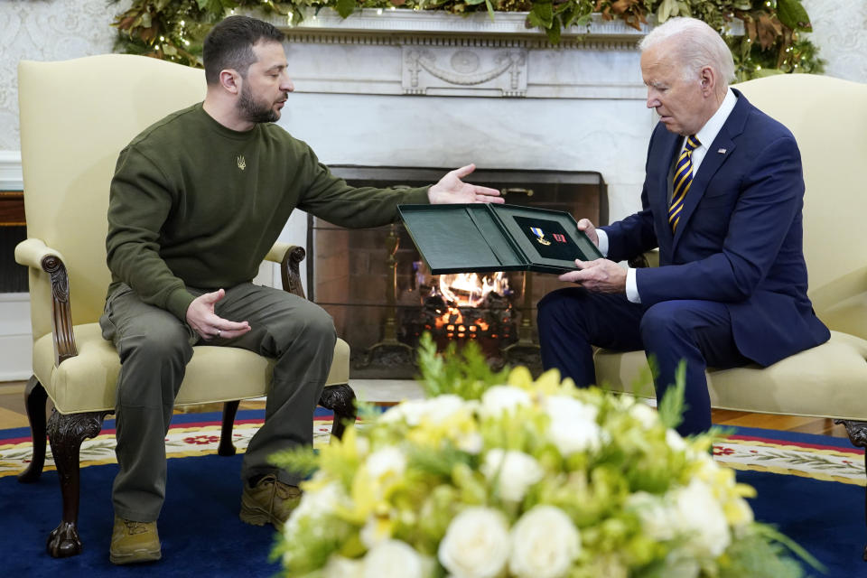 Ukrainian President Volodymyr Zelenskyy speaks after giving President Joe Biden a gift as they meet in the Oval Office of the White House, Wednesday, Dec. 21, 2022, in Washington. (AP Photo/Patrick Semansky)