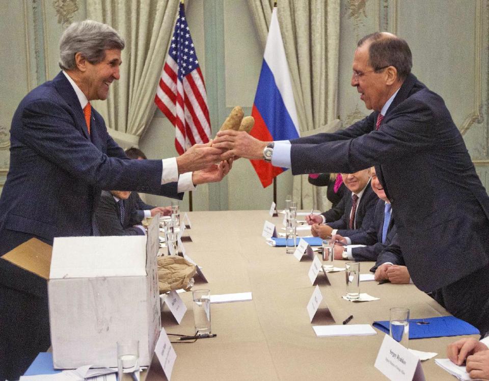FILE - int his Jan. 13, 2014, file photo, U.S. Secretary of State John Kerry, left, gives a pair of Idaho potatoes as a gift for Russia's Foreign Minister Sergey Lavrov at the start of their meeting at the U.S. Ambassador's residence in Paris, France, Monday, Jan. 13, 2014. Kerry is in Paris on a two-day meeting on Syria to rally international support for ending the three-year civil war in Syria. For some watchers of international diplomacy, the somber road to Syrian peace was overrun Monday by potatoes and furry pink hats. Kerry has spent nearly half of his first year as secretary of state jumping on and off airplanes and diving headlong into some of the world’s most difficult problems. (AP Photo/Pablo Martinez Monsivais, Pool)