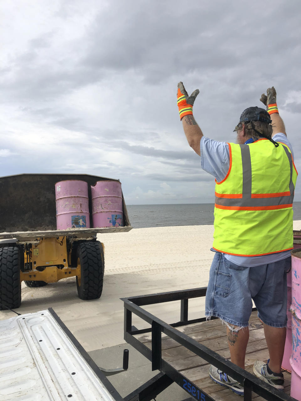 In a photo provided by the Harrison County Board of Supervisors, Harrison County Sand Beach crews remove trash cans from the Harrison County Sand Beach in Gulfport, Miss., Sunday, Aug. 23, 2020, in preparation for Hurricane Marco. (Pat Sullivan via Harrison County Board of Supervisors via AP)