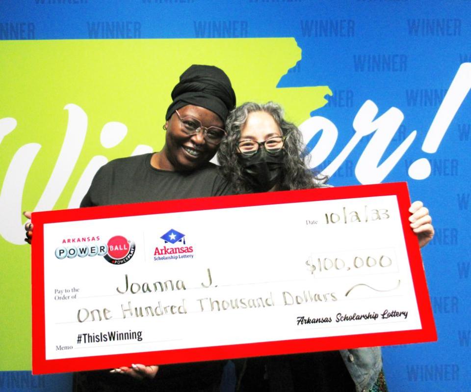 Joanna J. of Conway and her friend, LeaAnn, hold the ceremonial check for $100,000.