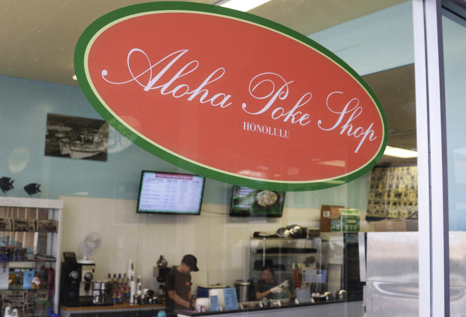 This Tuesday, April 16, 2019, photo shows Aloha Poke Shop, a store in Honolulu that received a letter from Chicago-based Aloha Poke Co. saying the Illinois company had trademarked "Aloha Poke" and the Hawaii company would need to change its name. Hawaii lawmakers are considering adopting a resolution calling for the creation of legal protections for Native Hawaiian cultural intellectual property. (AP Photo/Audrey McAvoy)