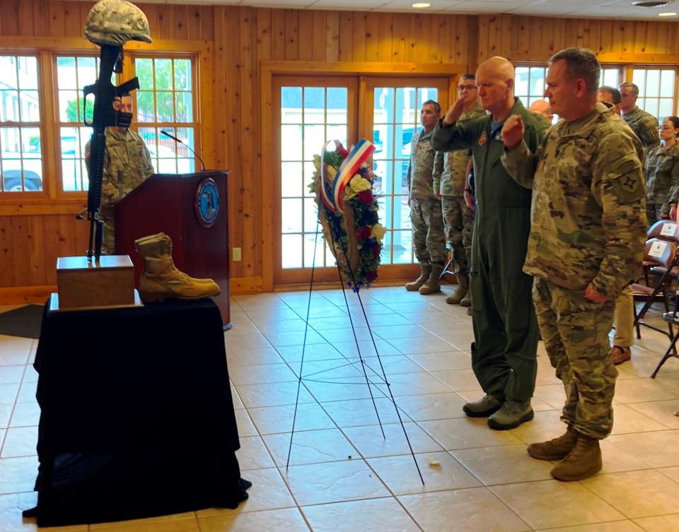 Maj. Gen. James Eifert, the adjutant general of Florida, and Command Sgt. Maj. David Lanham, the senior enlisted leader for the Florida National Guard, salute in front of a wreath placed during a ceremony recognizing the 20 anniversary of 9/11 and military members who died in the war on terrorism.